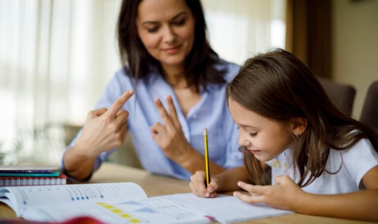 A math tutor helps a young student solve a problem, using her fingers to demonstrate a counting strategy while the child writes answers in a workbook.