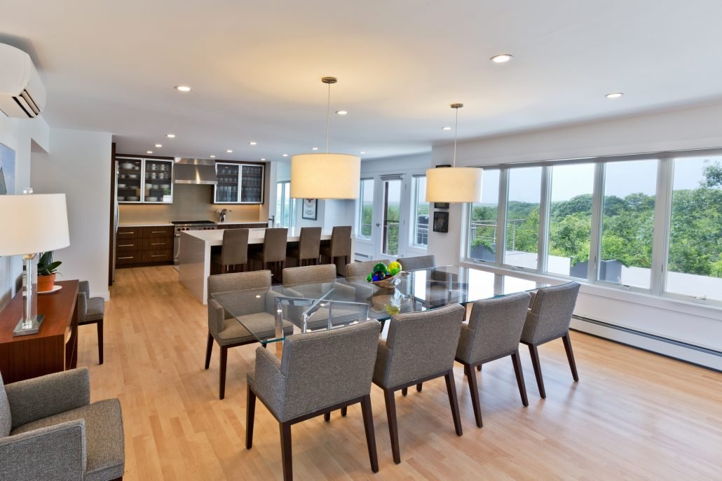 Bright, modern dining and kitchen space staged for an Airbnb listing with large windows and open layout.