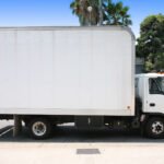 White box truck parked on a city street, used for delivery and small freight services.