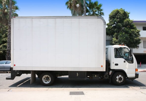 White box truck parked on a city street, used for delivery and small freight services.
